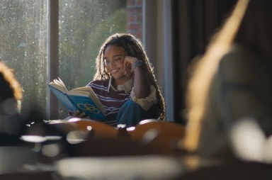 Lachend meisje leest een boek