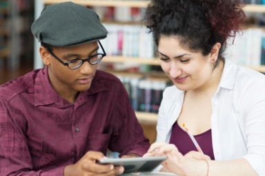 Man en vrouw bekijken een bericht op een smartphone in de bibliotheek